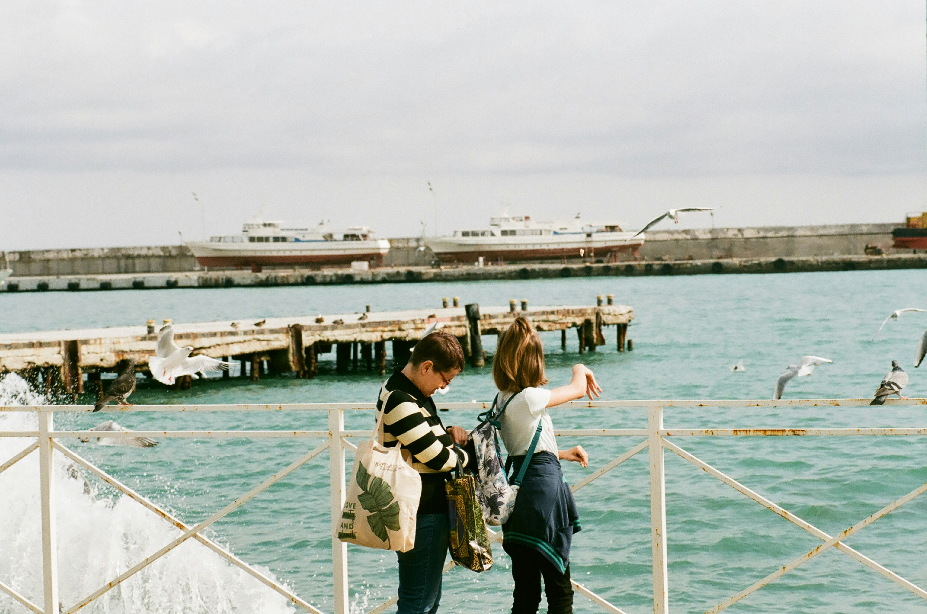 a couple of people that are standing on a pier