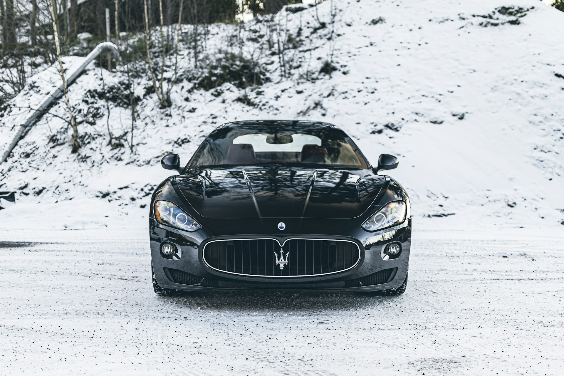 a black sports car driving down a snowy road