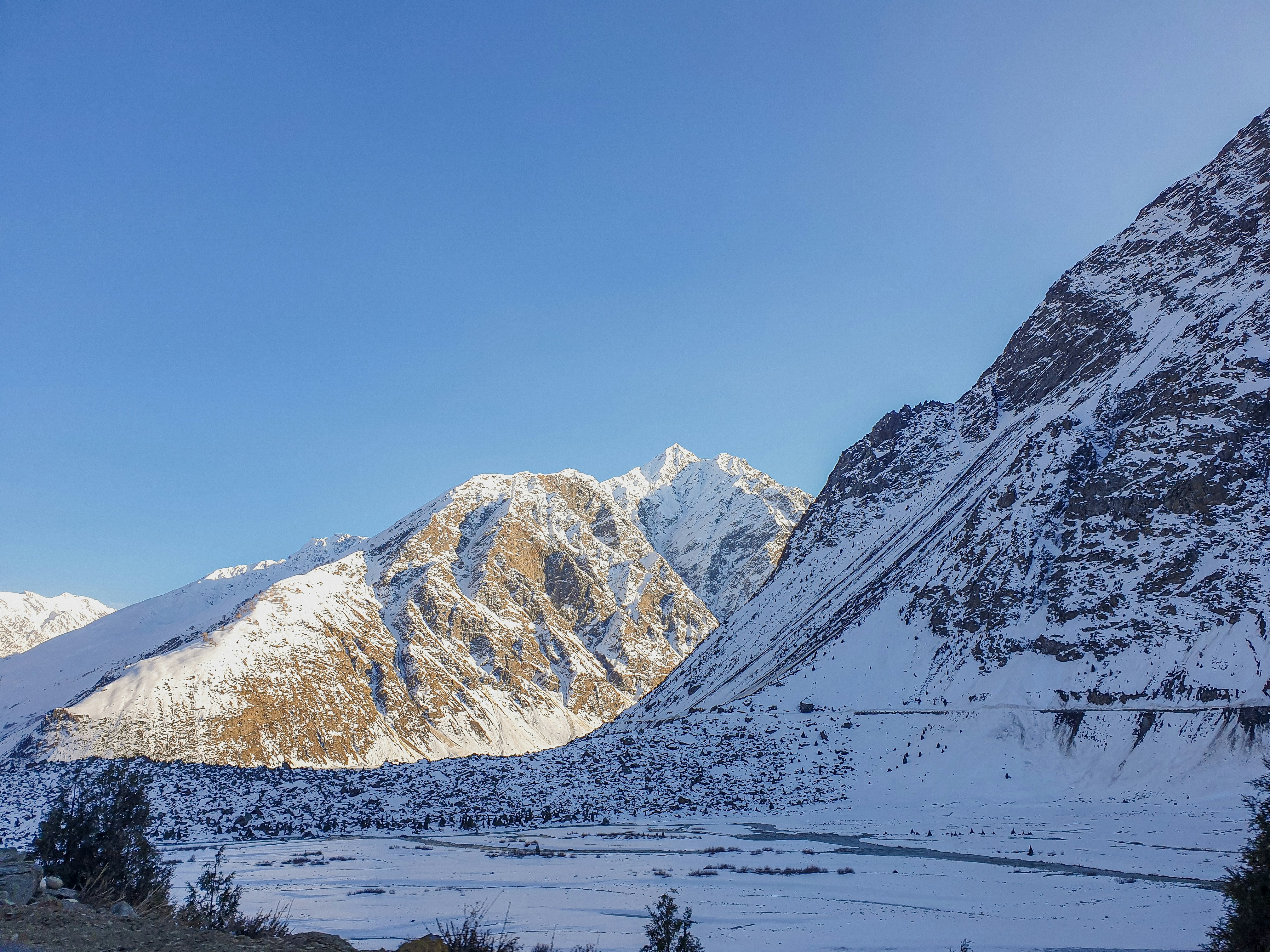 a snowy mountain range with a road in the foreground