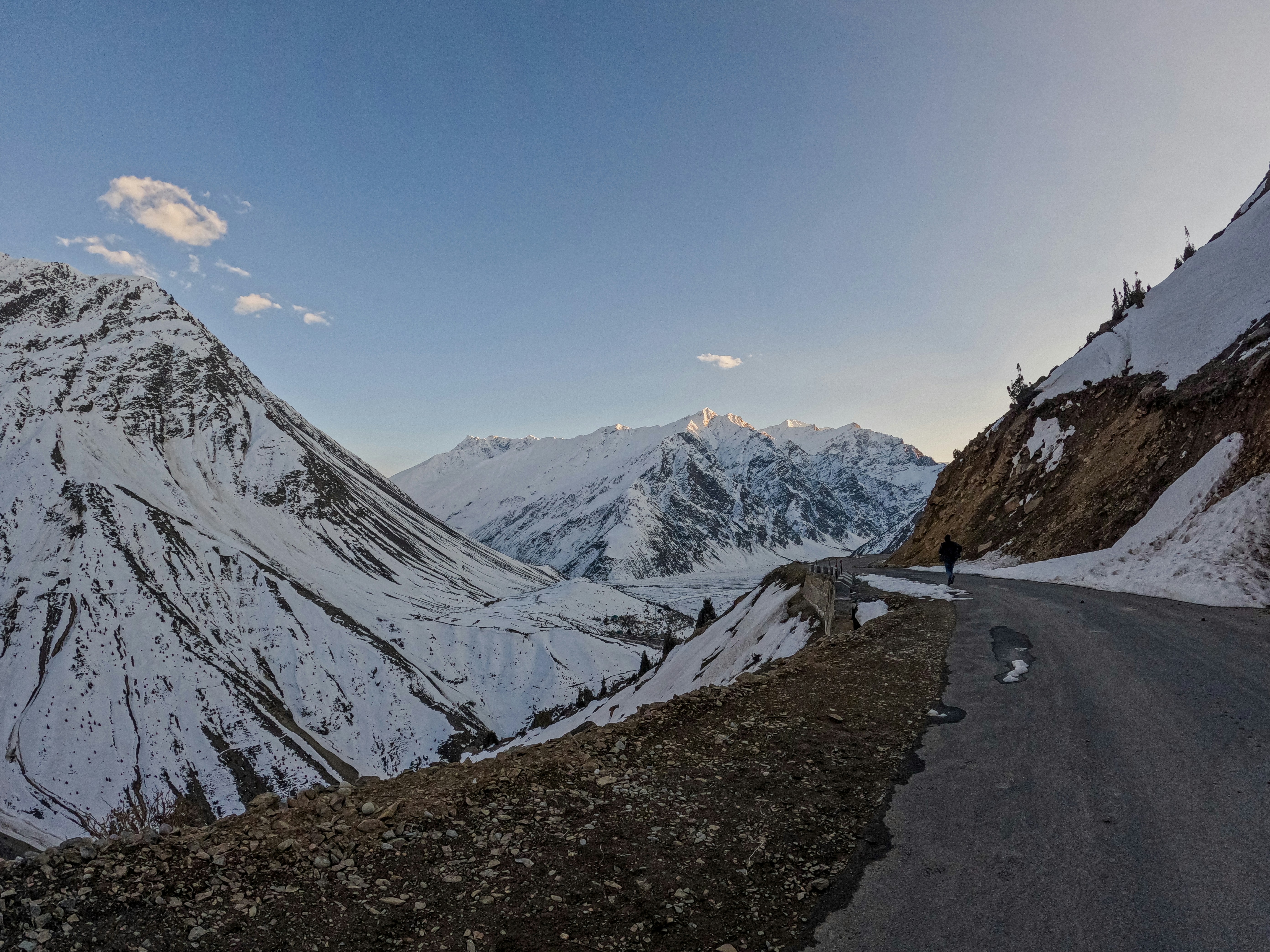 a person standing on the side of a mountain road