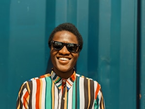 Portrait of El Loco Magnético smiling confidently with a blue and gold background.