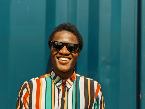 Portrait of El Loco Magnético smiling confidently with a blue and gold background.