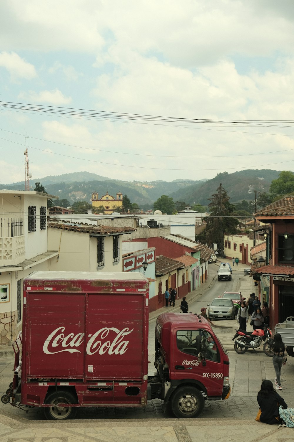 a coca - cola truck parked on the side of a road