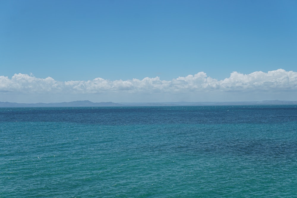 a large body of water sitting under a blue sky