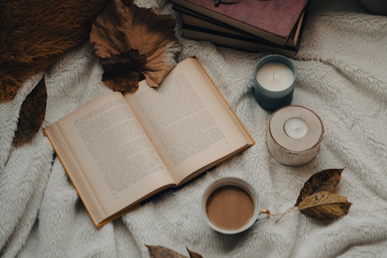 A cozy corner with soft blankets, candles, and a book open to a page about self-care.