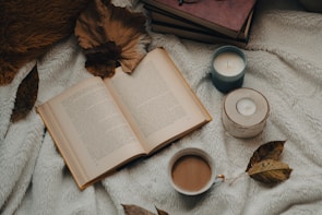 An open book surrounded by cozy reading materials.