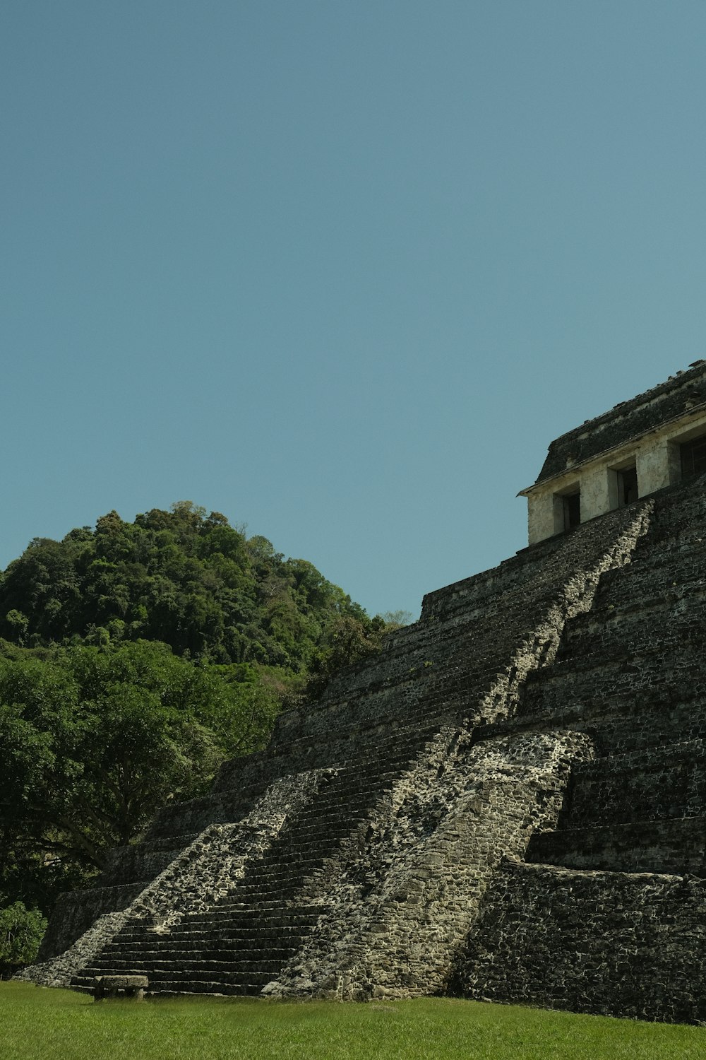 a large stone structure sitting on top of a lush green field