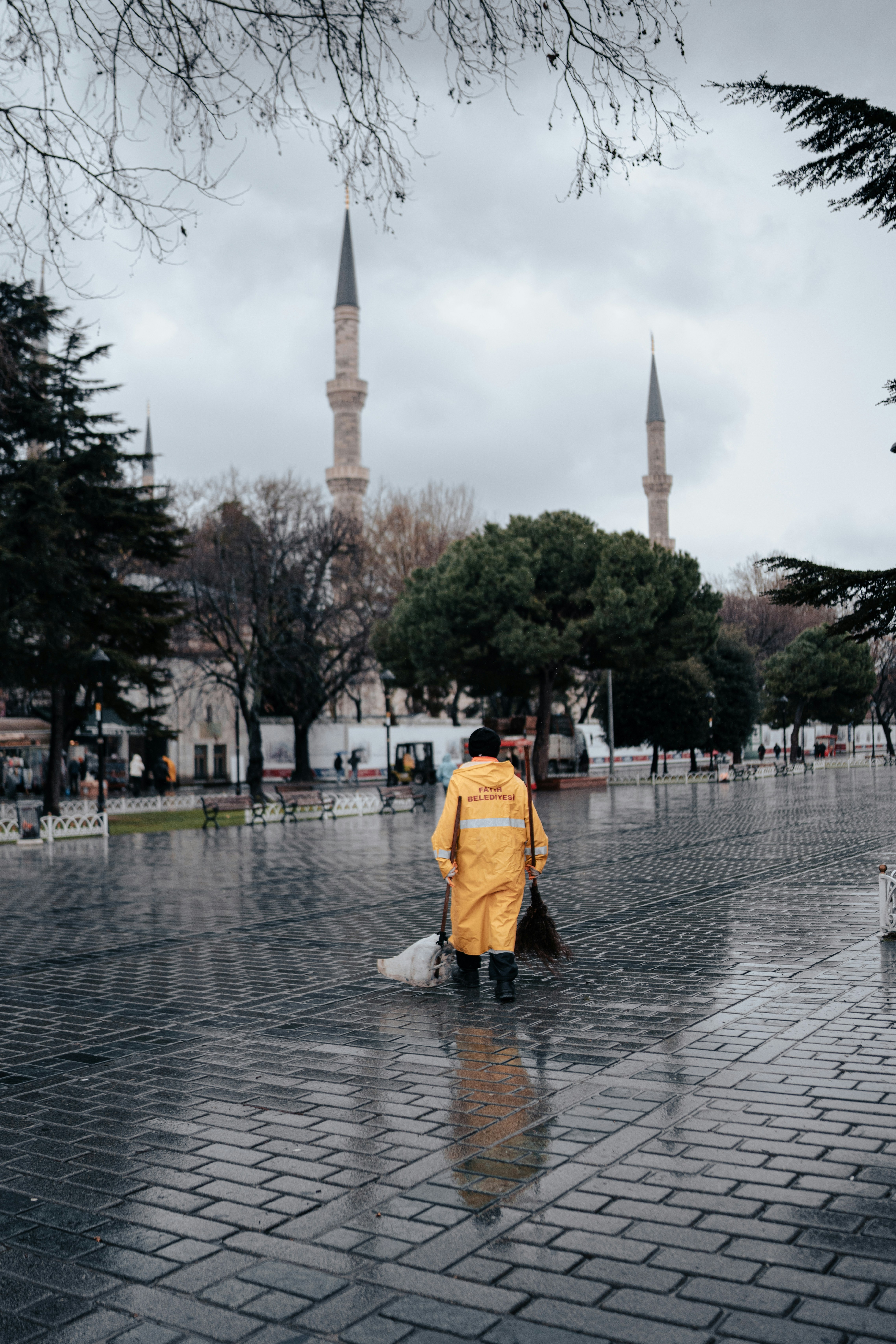 a man in a yellow jacket walking down a street