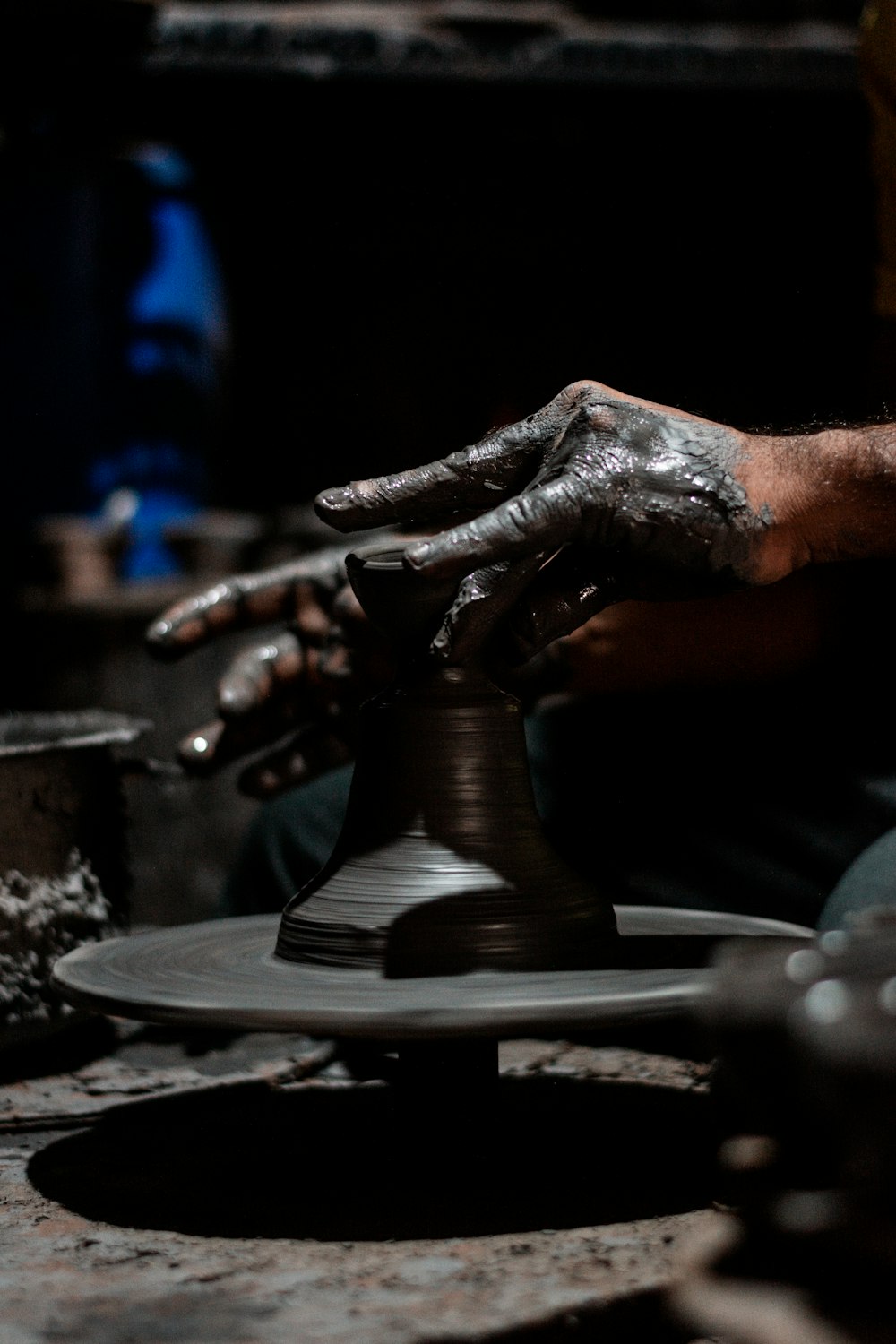 a person is making a vase out of clay