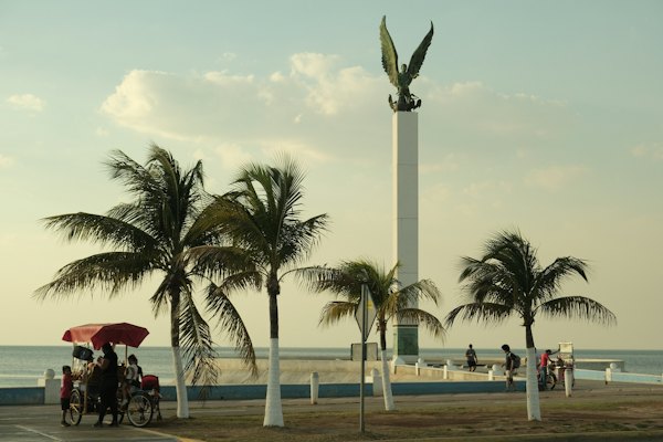 A group of people riding a horse drawn carriage down a street — Campeche, Mexico