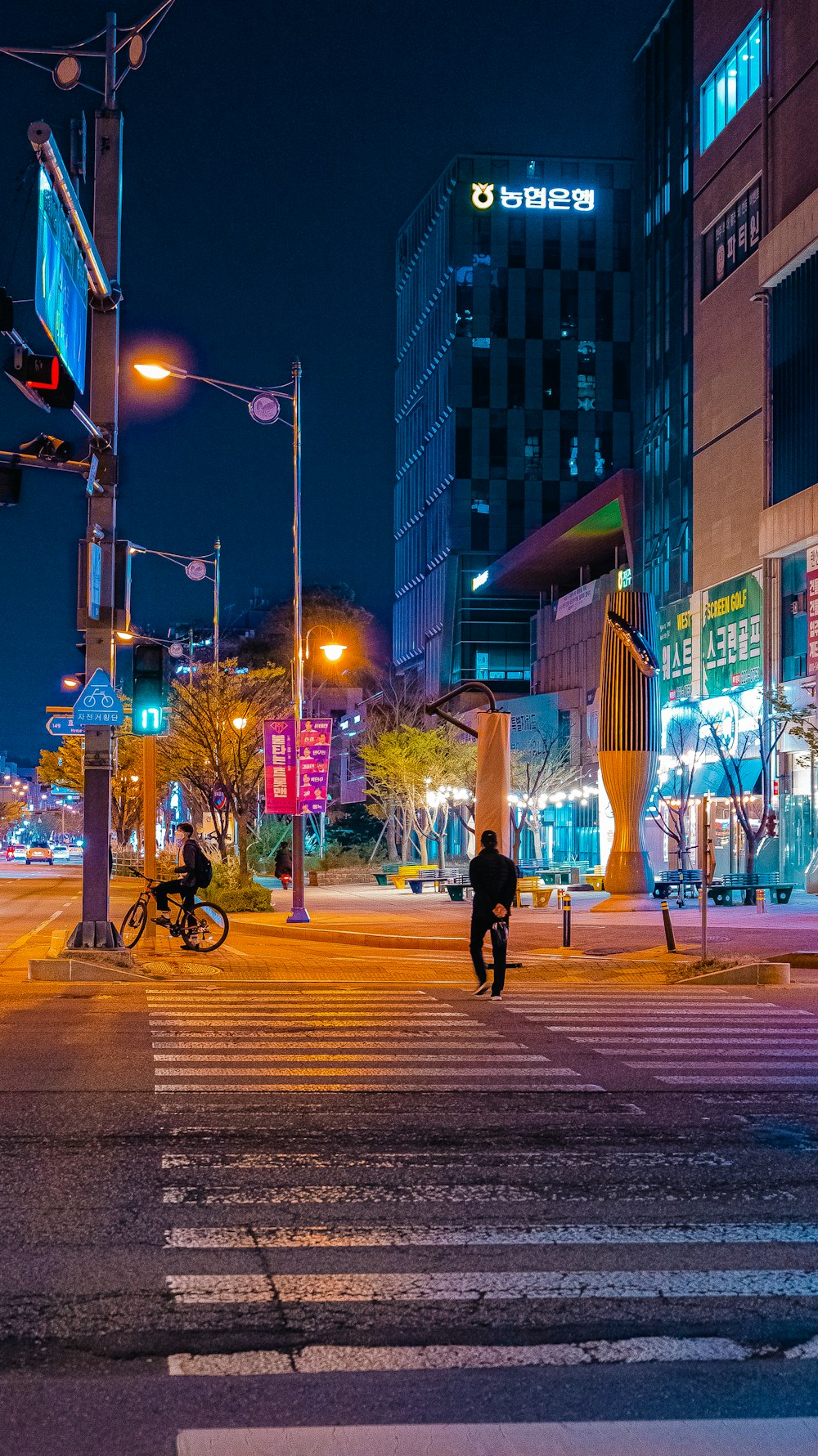 a man walking across a street at night