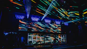 A panoramic view of the nightclub’s immersive lighting and energetic crowd captured in deep black and vibrant neon hues.