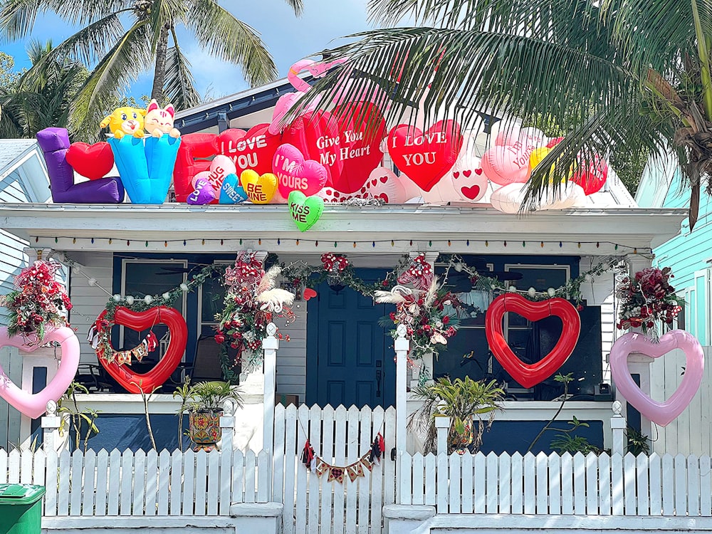 a house decorated for valentine's day with heart balloons