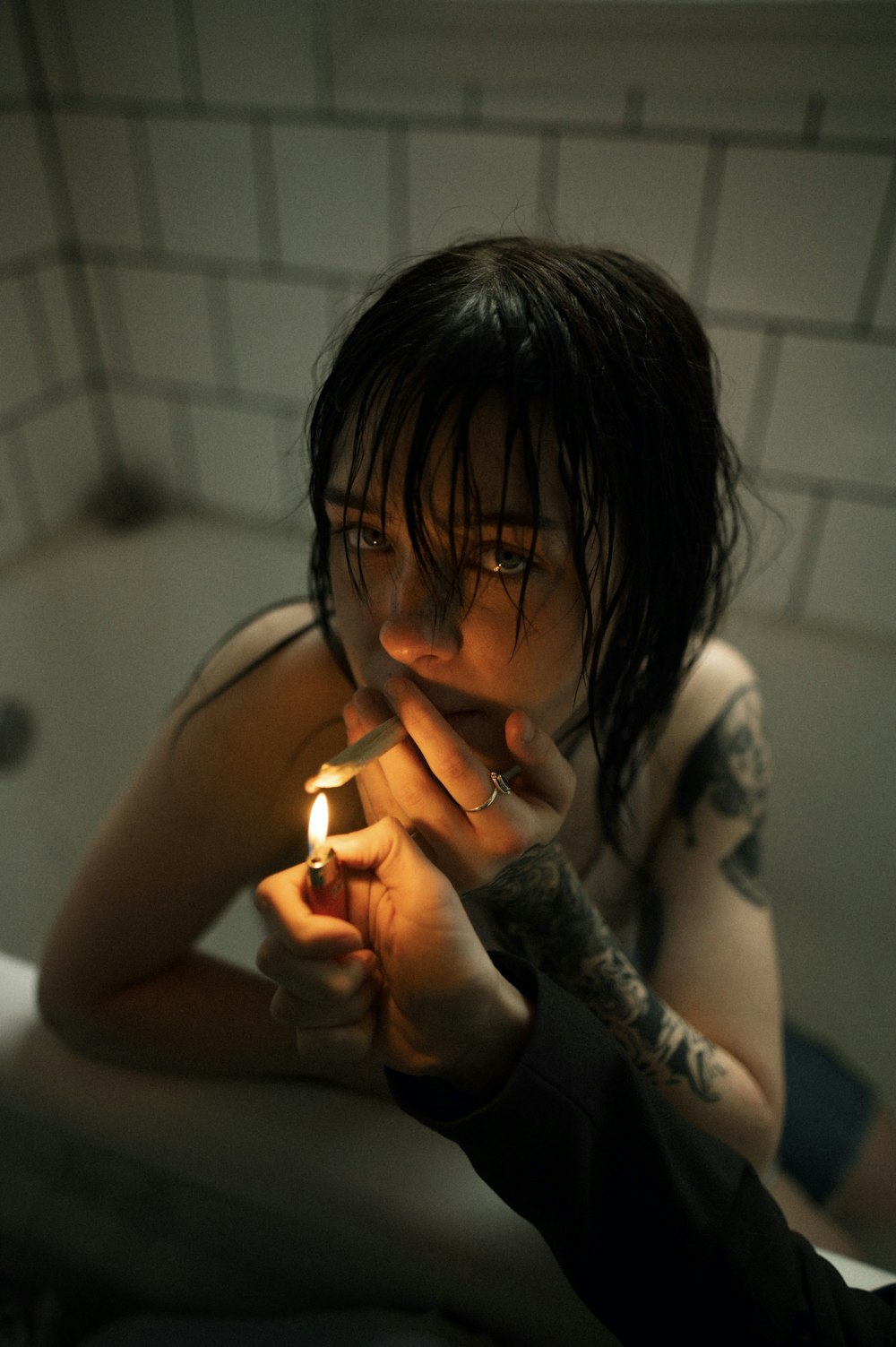 a woman sitting in a bathtub holding a lit candle