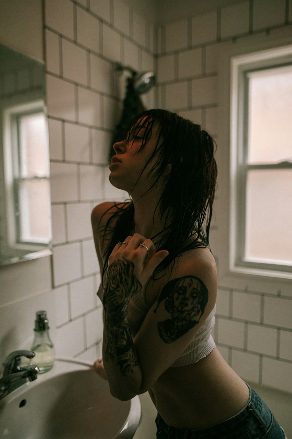 a woman standing in front of a bathroom sink