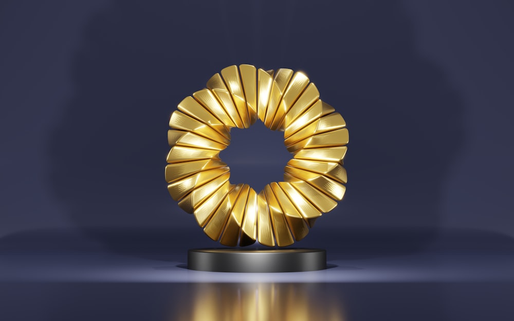 a golden object on a black stand on a blue background