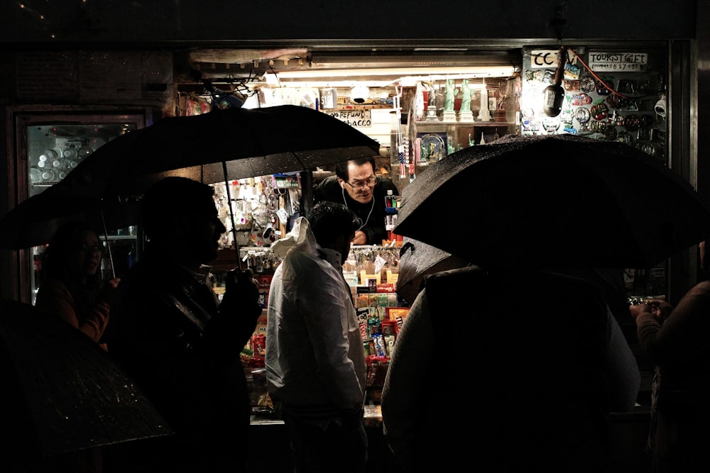 a group of people with umbrellas in the dark