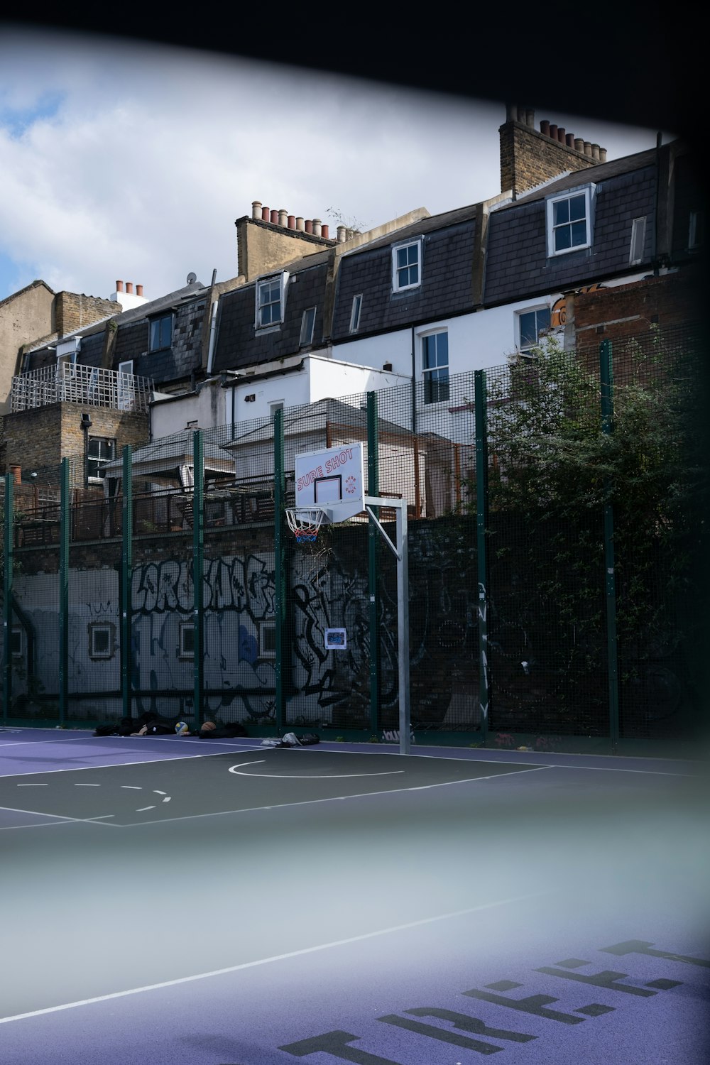 a basketball court with graffiti on the side of it