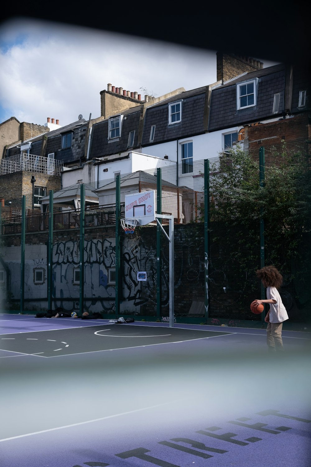 a young boy holding a basketball on a basketball court