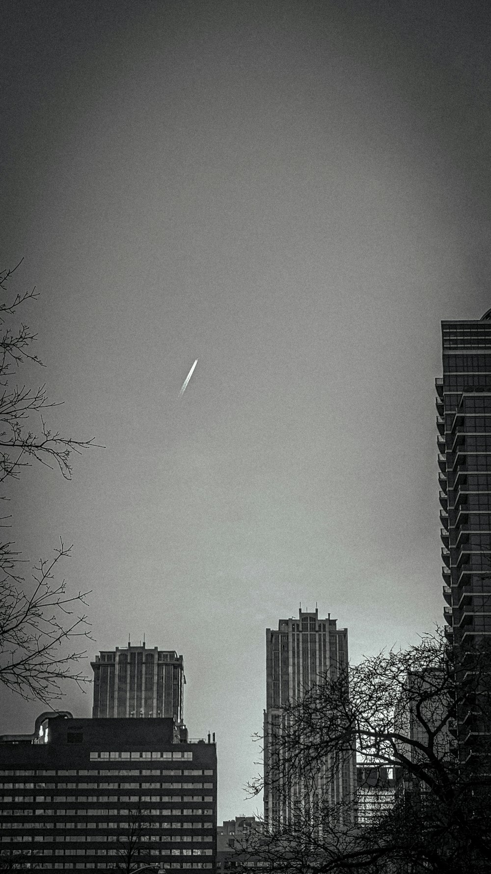 a plane flying over a city with tall buildings