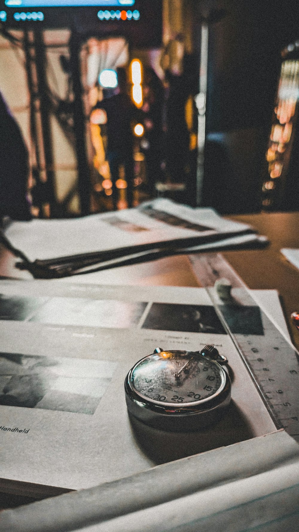 a table topped with lots of papers and a pocket watch