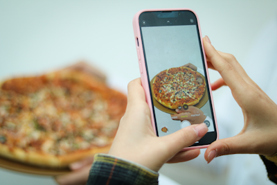 A customer happily ordering pizza on a smartphone at home.
