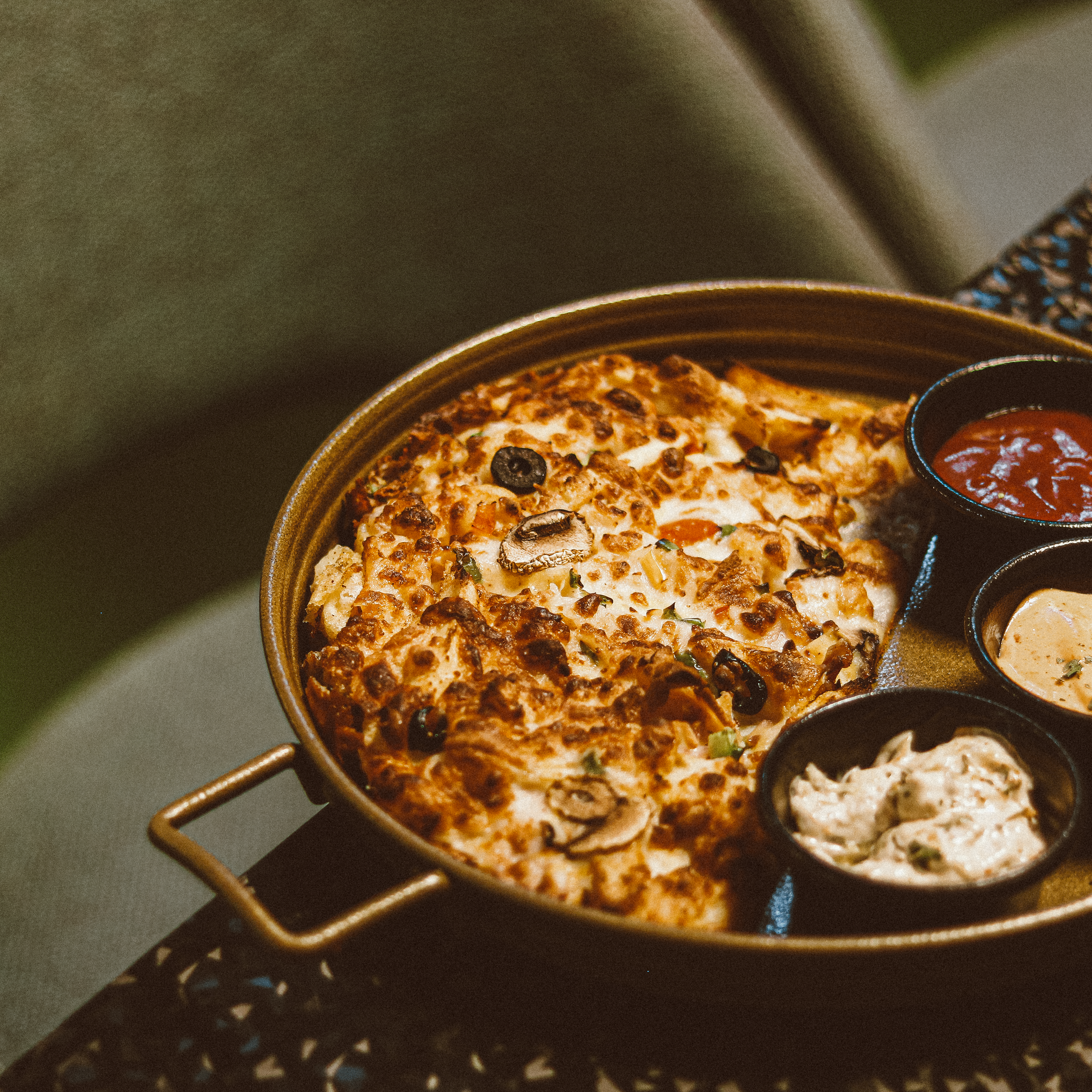 a pizza in a pan with sauces and condiments