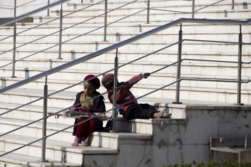 a couple of people that are sitting on some stairs