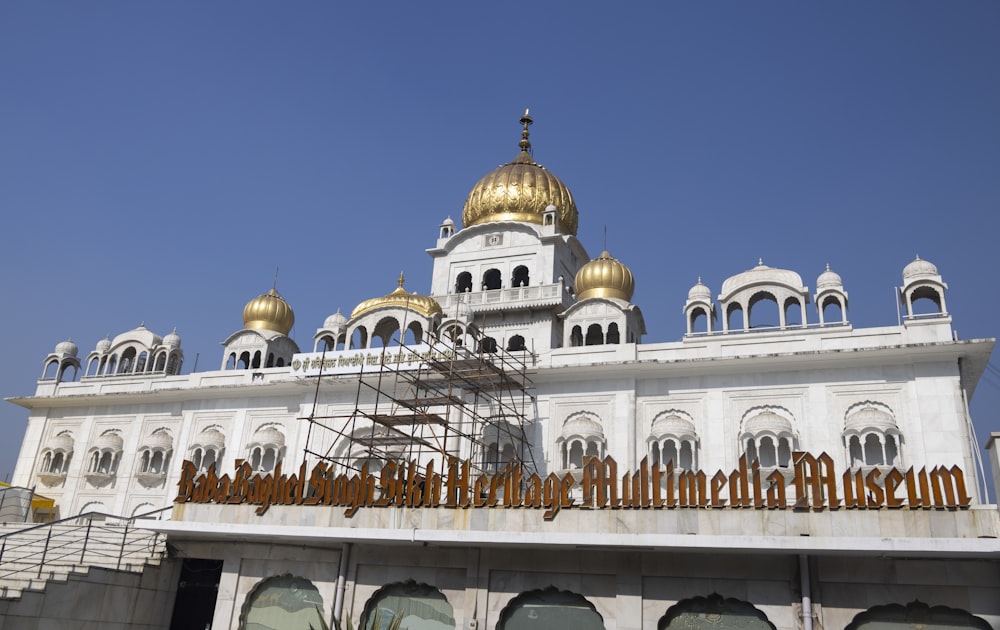 a large white building with gold domes and scaffolding