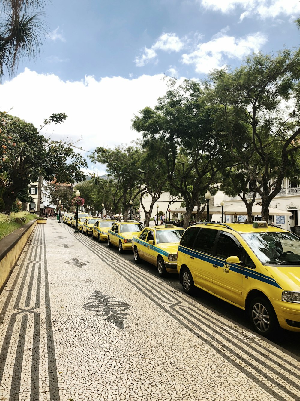 a row of parked cars sitting on the side of a road