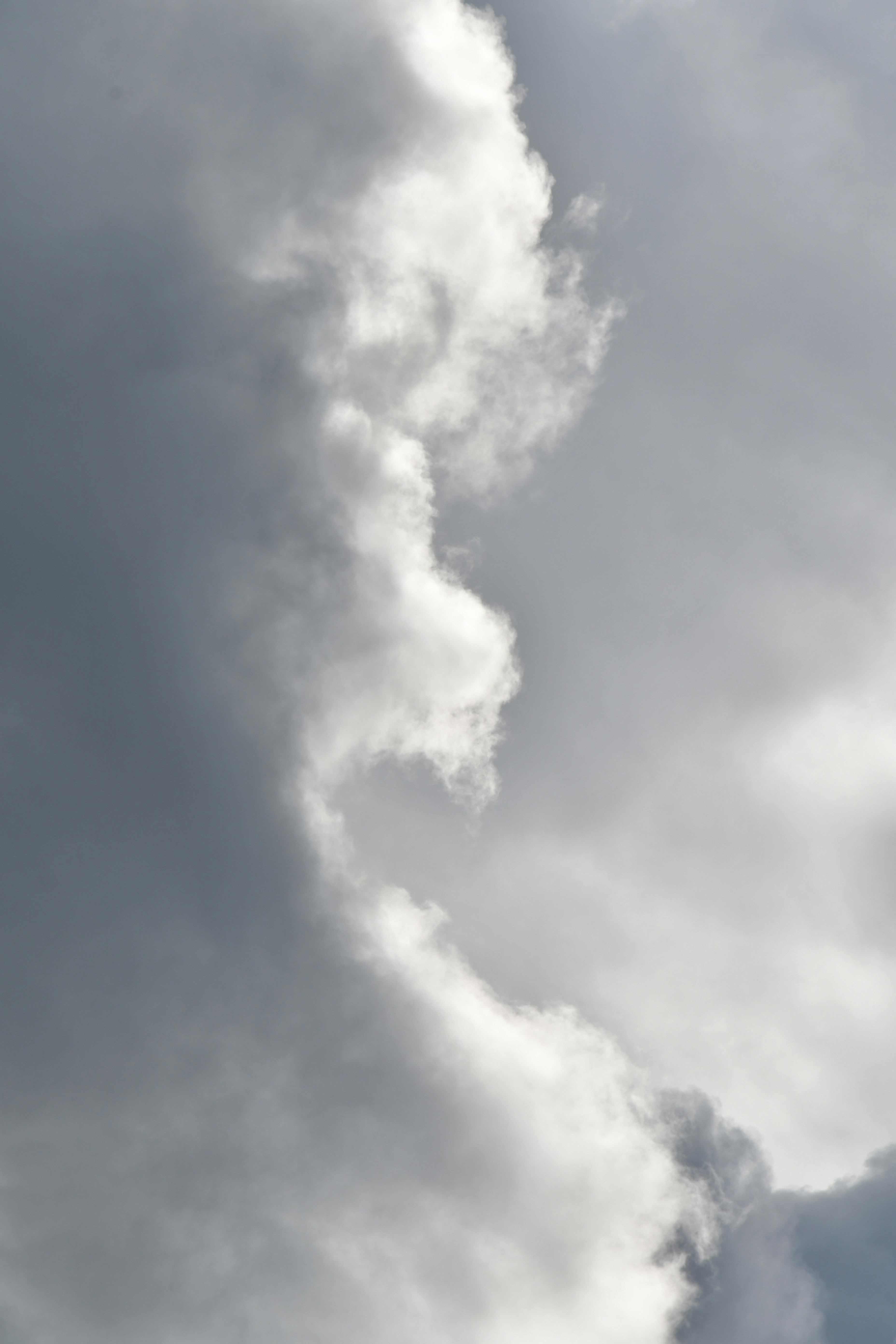 a plane flying through a cloudy sky on a sunny day