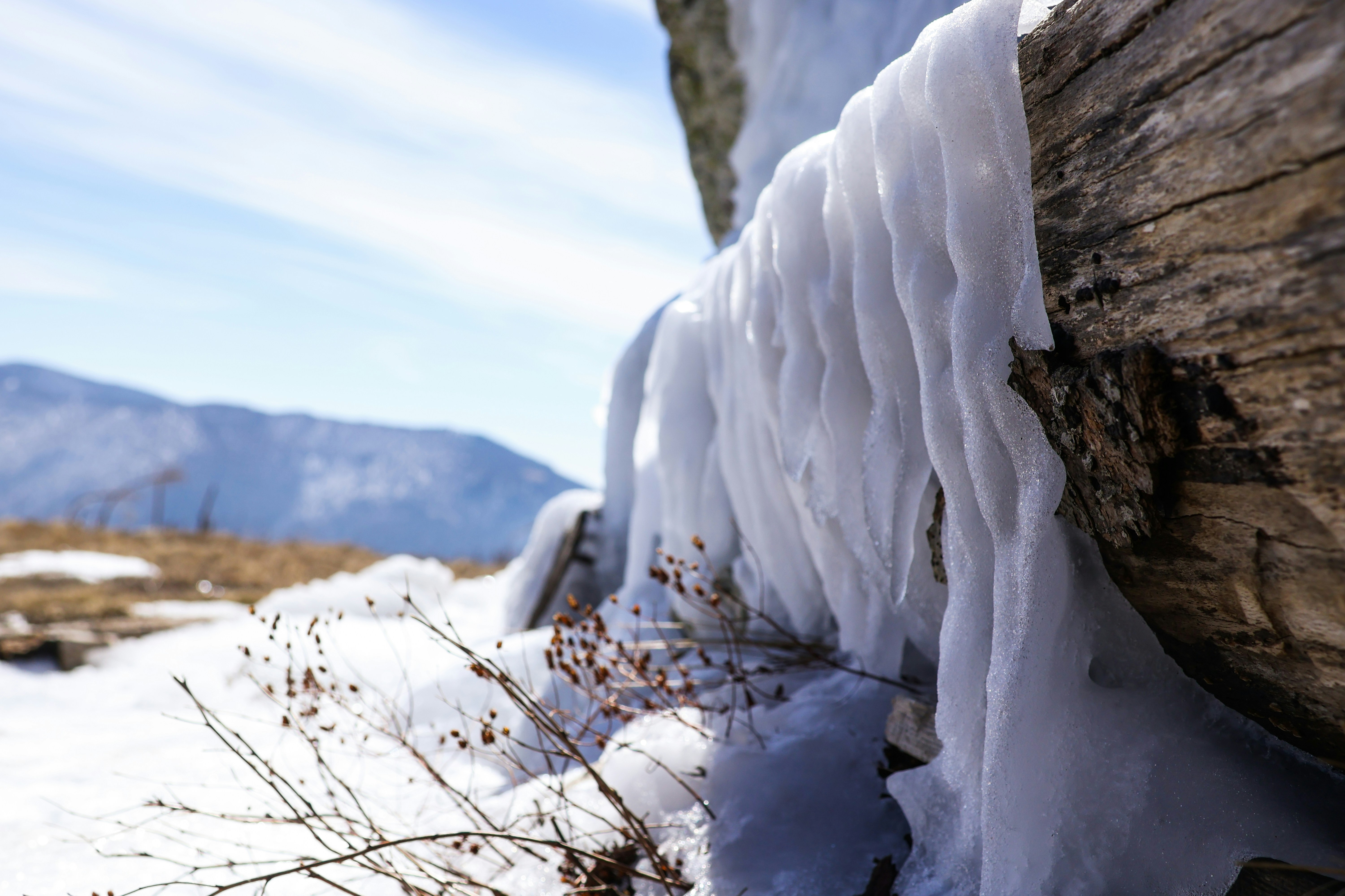 a wooden bench covered in ice and snow