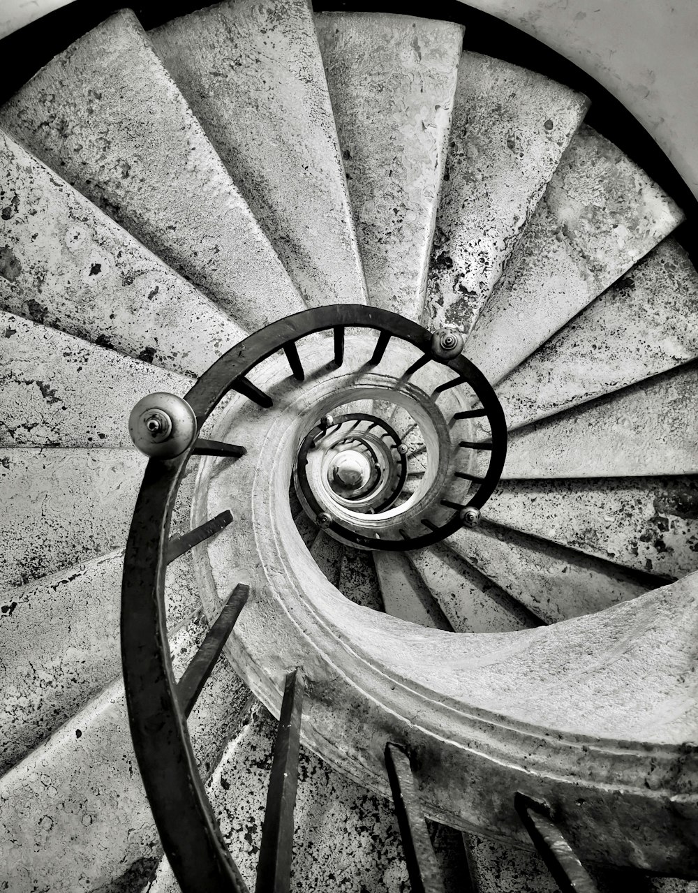 a black and white photo of a spiral staircase