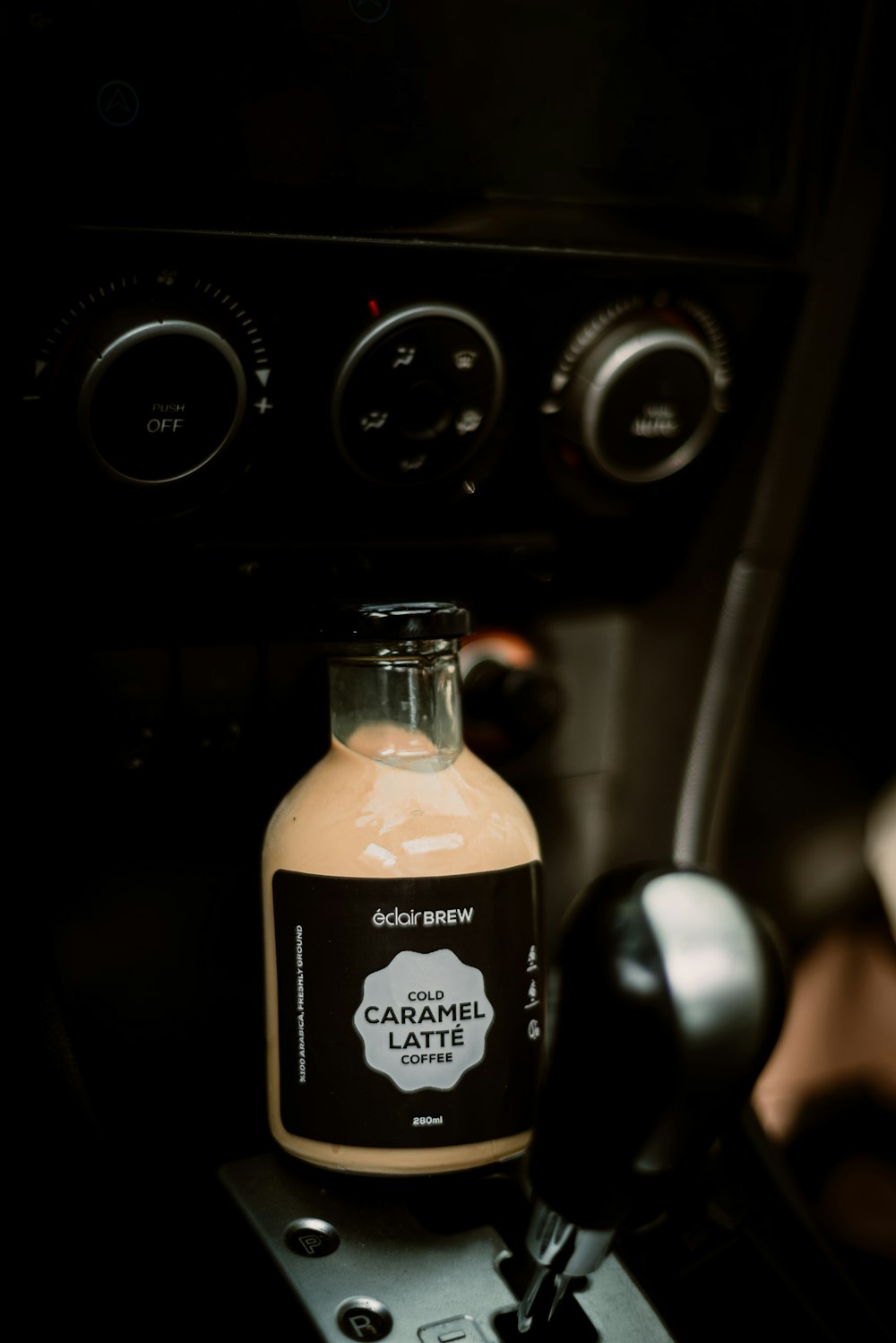 a bottle of caramel sits on the dash of a car