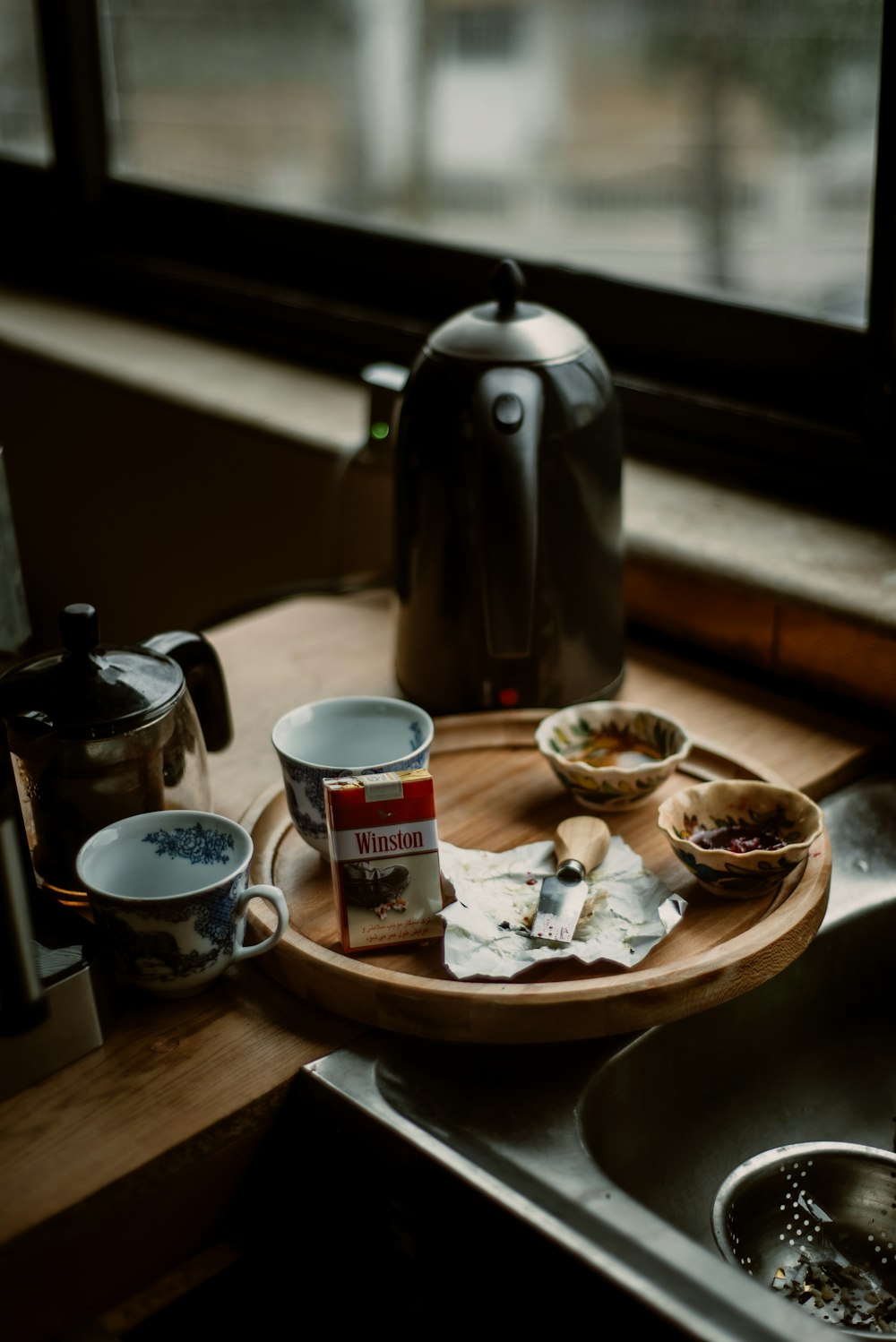 a wooden tray filled with food next to a window