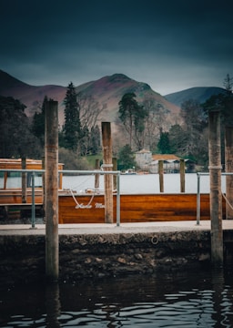 A freshly built wooden dock with a boat lift near a peaceful lake.