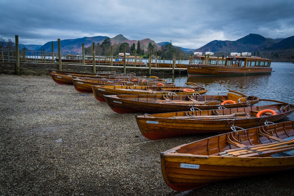 a row of wooden boats sitting on top of a lake