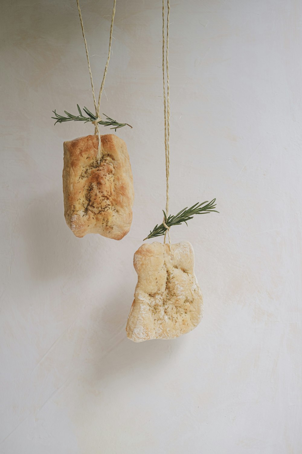 a couple of pieces of bread hanging from strings