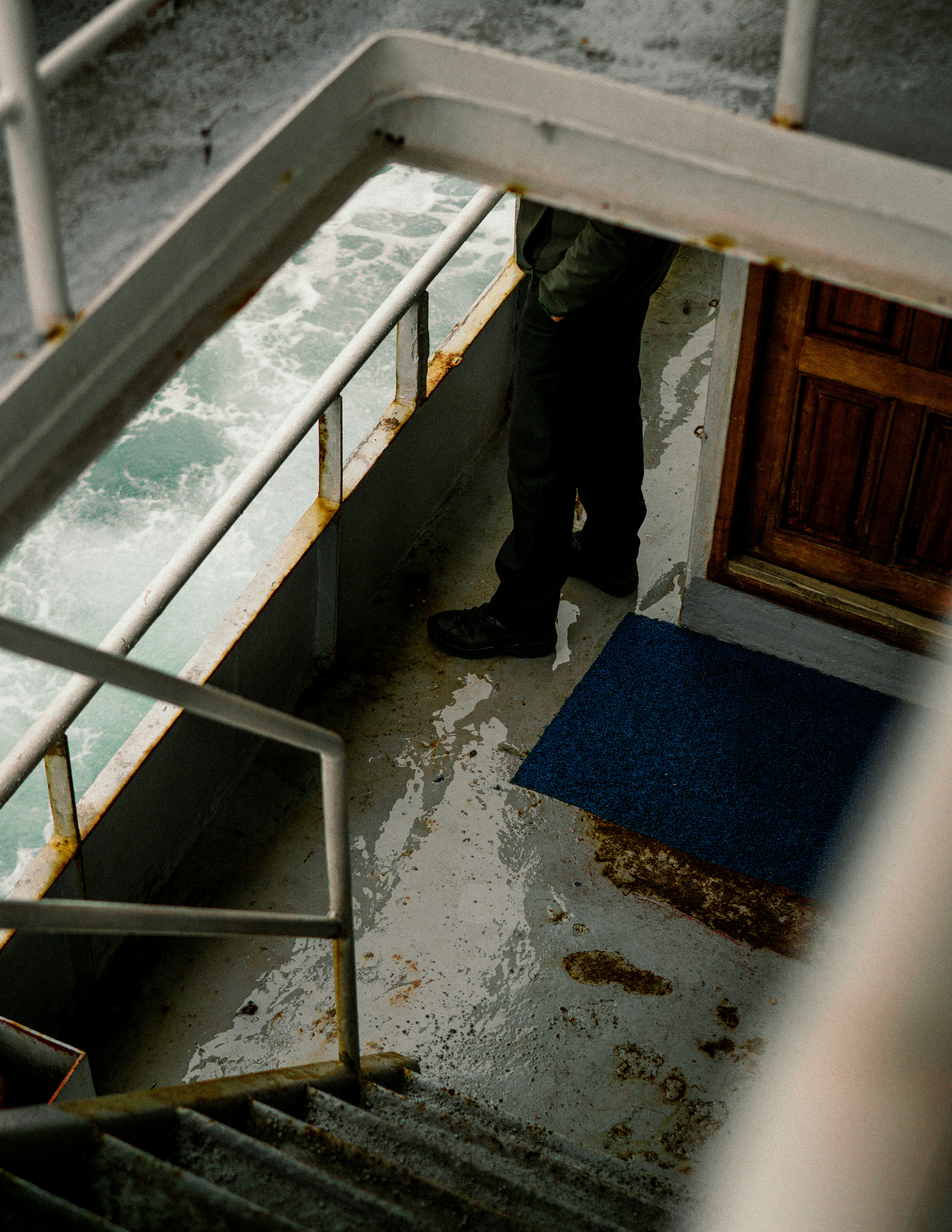 a man standing on a boat steps next to the water