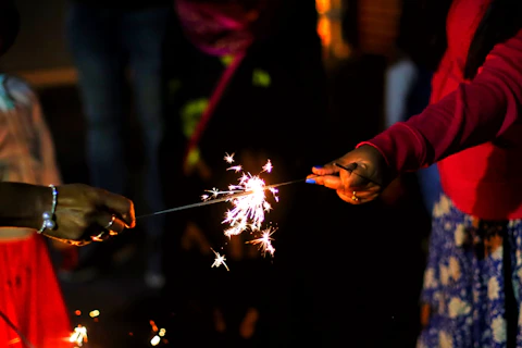 two people holding sparklers in their hands