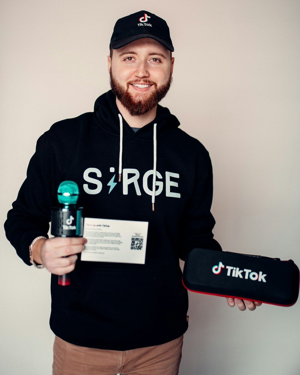 a man in a black hoodie holding a skateboard