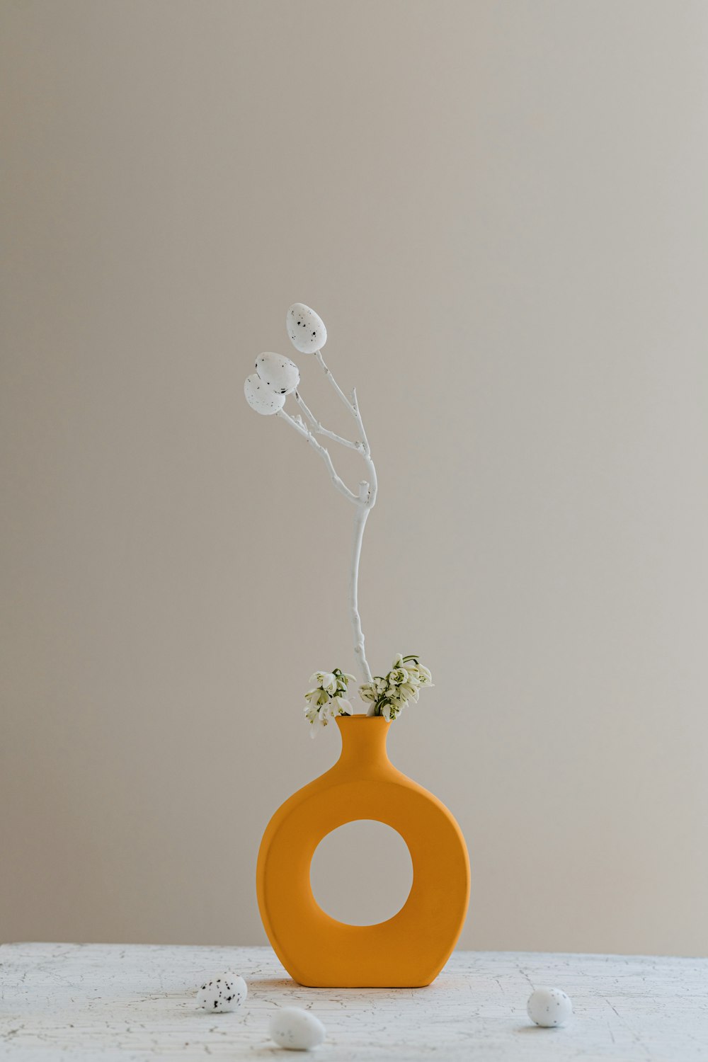 un jarrón con una flor sobre una mesa