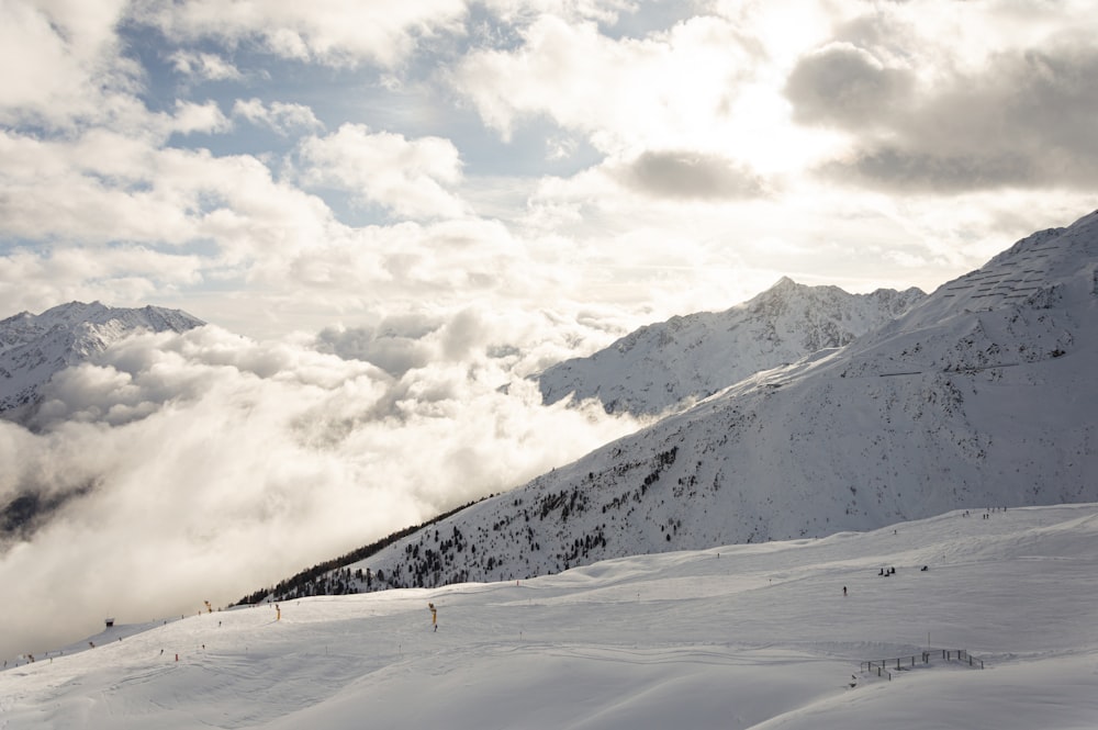 a snow covered mountain with clouds in the sky