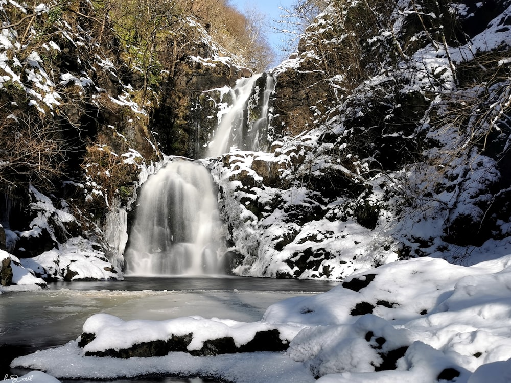 Ein Wasserfall inmitten eines verschneiten Waldes