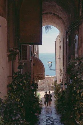 two people walking down a narrow alley way