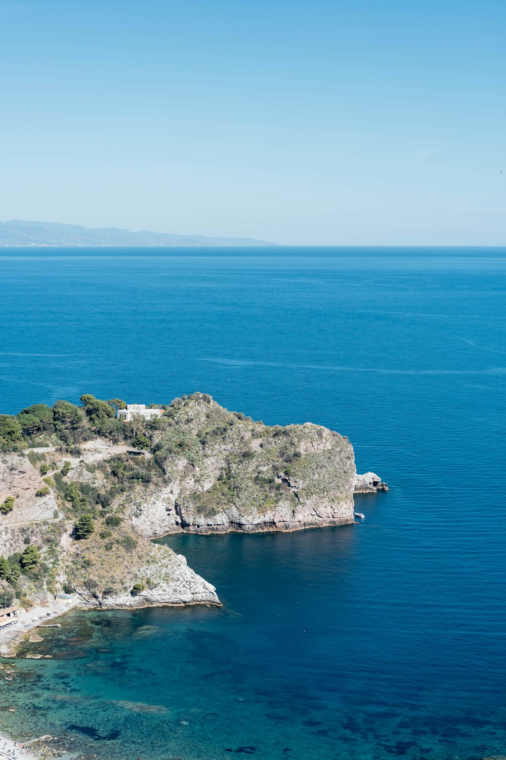 a large body of water sitting next to a lush green hillside