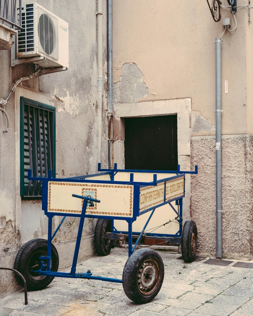 a blue cart sitting next to a building