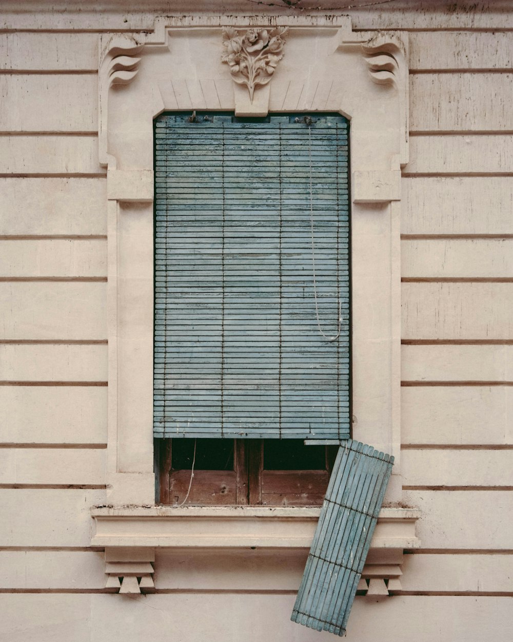 a window with a blue curtain and a window sill