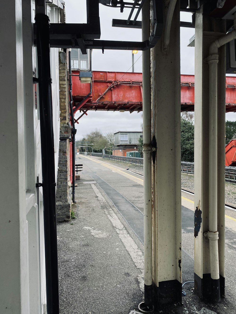 a train station with a red bridge in the background