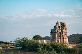 a very tall building sitting on top of a lush green field